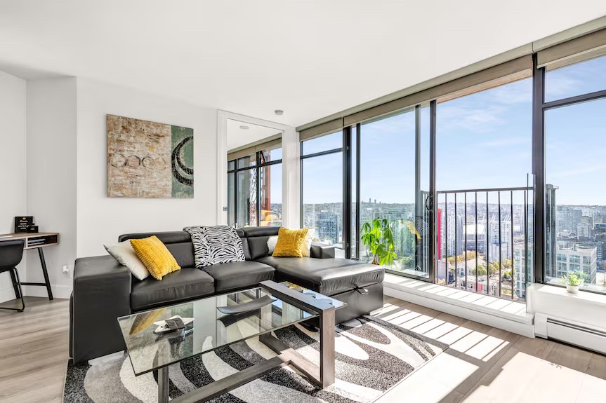 A bright apartment living room with floor-to-ceiling windows over the city.
